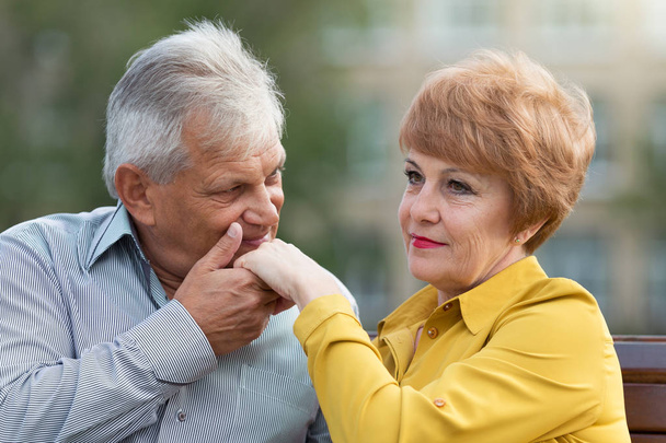 Ein alter Mann küsst die Hand seiner Frau - Foto, Bild