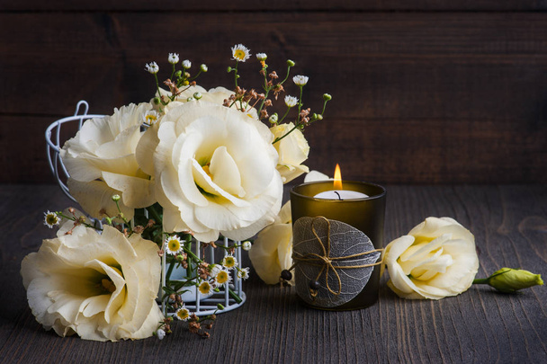 gelbe Lisianthus-Blumen und brennende Kerze - Foto, Bild