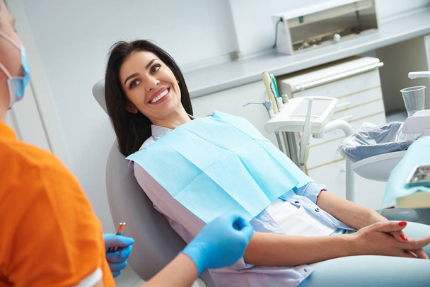 Smiling lady receiving teeth treatment in dental clinic - Zdjęcie, obraz
