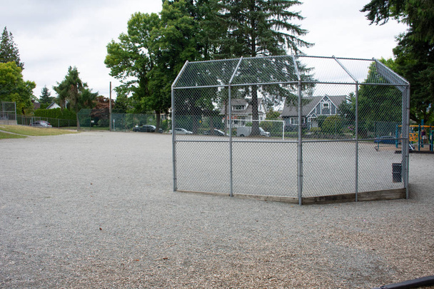 Diamante de béisbol o softbol a través de una valla en un parque en una pequeña ciudad
 - Foto, Imagen
