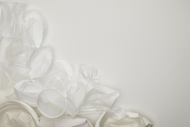 a gyűrött műanyag csészék és lemezek felülnézete fehér háttérrel, másolási területtel - Fotó, kép