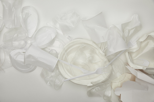 a gyűrött műanyag csészék, tányérok és kartondobozok felülnézete fehér alapon  - Fotó, kép