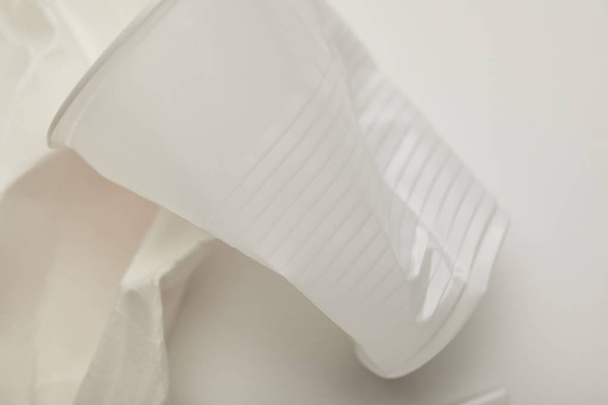 Close-up weergave van verfrommeld plastic beker op witte achtergrond - Foto, afbeelding