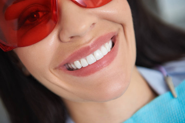 Усміхнена жінка, яка отримує лікування зубів у стоматологічній кімнаті
 - Фото, зображення