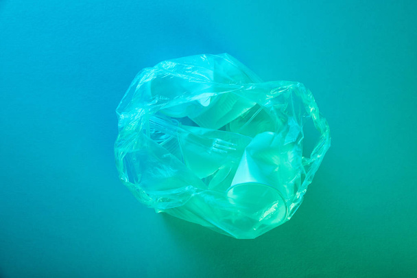 vista superior de la bolsa de plástico arrugado con basura desechable en luz azul
 - Foto, imagen