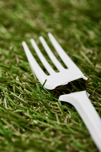 close up view of broken disposable plastic fork on green grass - Photo, Image