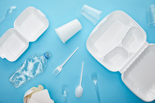 top view of plastic and cardboard rubbish on blue background - Photo, Image