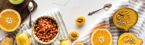 panoramic shot of pumpkin, berries, apricots with spoons on marble surface - Foto, immagini