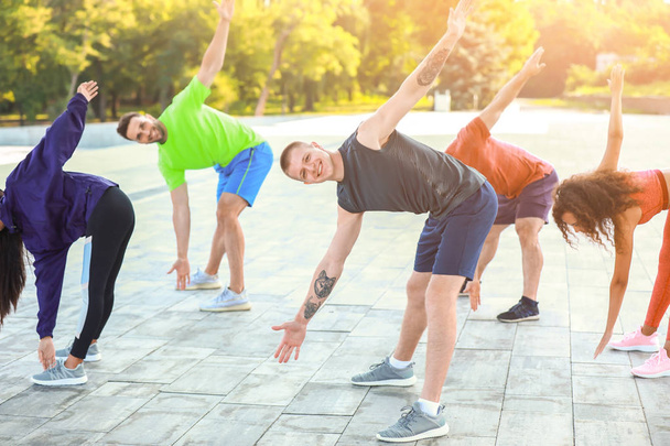 Grupo de jóvenes deportistas entrenando juntos al aire libre
 - Foto, imagen