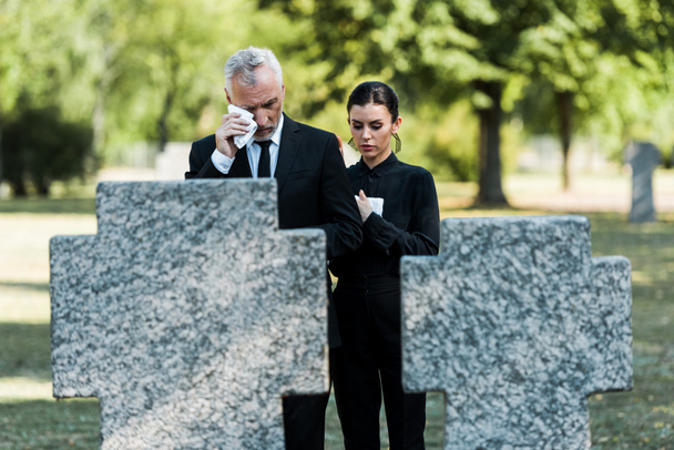 szelektív középpontjában ideges ember sír, közel a nő a temetésen  - Fotó, kép