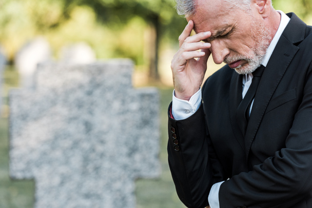 turbato anziano uomo toccare faccia su funerale
  - Foto, immagini