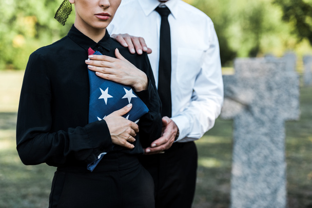 cropped view of woman with american flag near man on funeral  - Фото, зображення