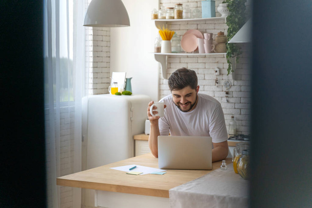 Smiling young man is working at home - Foto, Bild