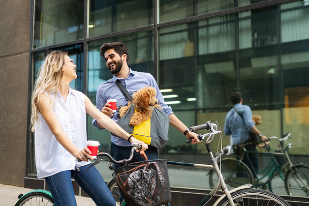 Attractive woman and handsome man spending time together with dog and bicycles - Fotoğraf, Görsel