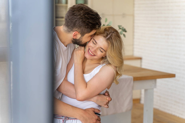 Happy husband kissing his wife at home - Valokuva, kuva