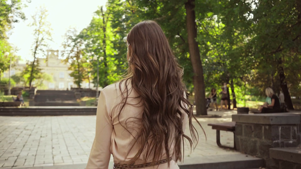  νεαρή γυναίκα με το μπουκέτο περπάτημα και κάθεται στις σκάλες στο πάρκο - Πλάνα, βίντεο