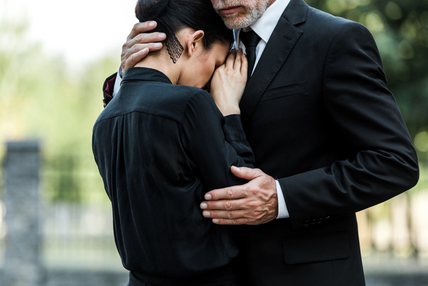 nyírt kilátás szomorú idős férfi felölelő nő a temetésen  - Fotó, kép