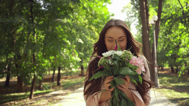 young woman getting flowers in park - Imágenes, Vídeo