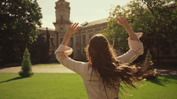 щаслива молода жінка з довгим волоссям біжить на траві
 - Кадри, відео
