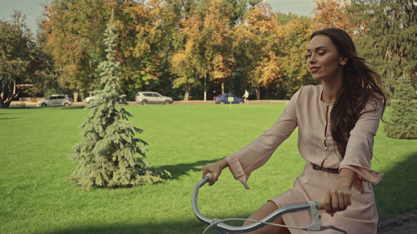 молодая женщина на велосипеде в парке - Кадры, видео