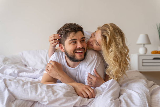 Young woman is hugging boyfriend in bedroom - Photo, Image