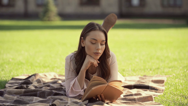 a takaró és olvasott fiatal nő - Felvétel, videó