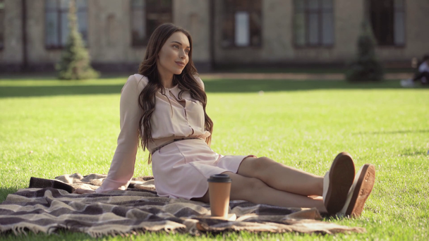 мечтательная молодая женщина сидит на одеяле возле кофе, чтобы пойти
 - Кадры, видео