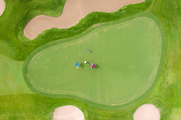 Yeşil golf sahasında oyuncuların havadan görünümü. Golfçü üzerinde oynuyor - Fotoğraf, Görsel