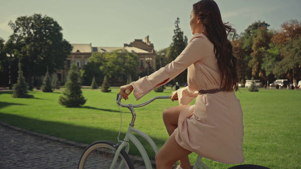 mladá žena jezdecká na kole blízko trávy - Záběry, video