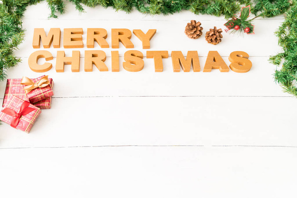High angle view of Merry Christmas message sitting on a wooden table with some decorations and copy space - Foto, Imagen