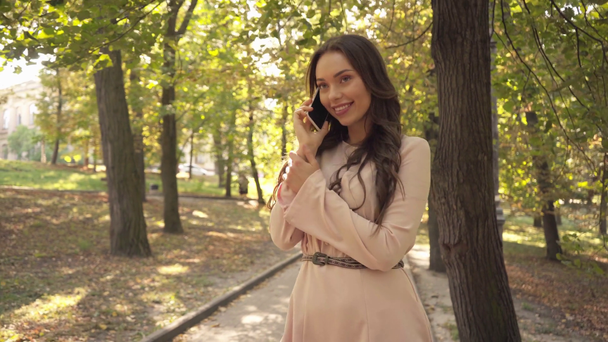 Boldog fiatal nő beszél a smartphone-ban park - Felvétel, videó