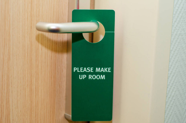Puerta cerrada de la habitación del hotel con por favor hacer signo de habitación
 - Foto, Imagen
