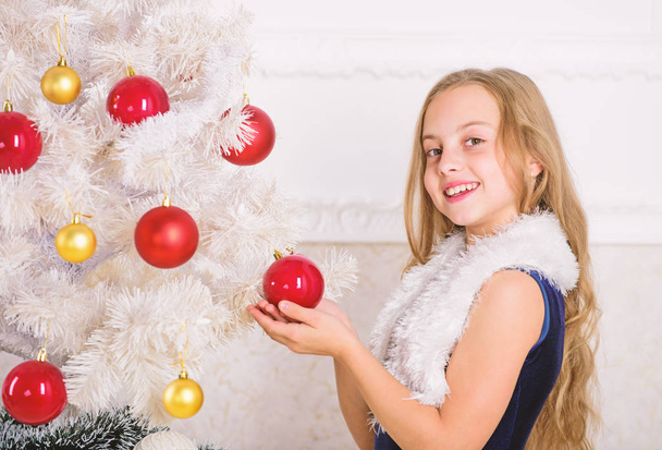 Family holiday concept. Girl velvet dress feel festive near christmas tree. Spread christmas cheer. Kid happy because holiday season arrives. Winter holiday concept. Very special time of year - Фото, изображение