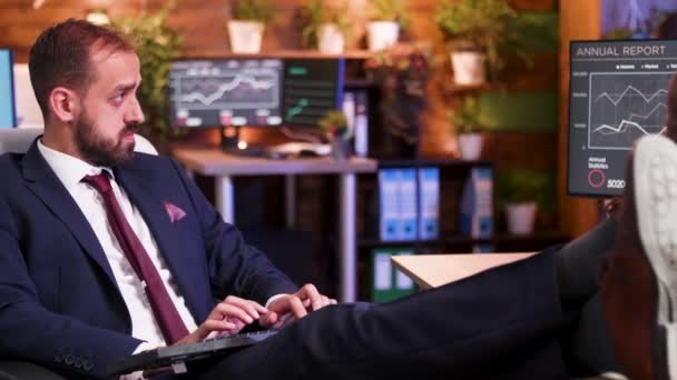 Entspannter Geschäftsmann mit Füßen im Schreibtischbüro während der Nachtstunden - Filmmaterial, Video