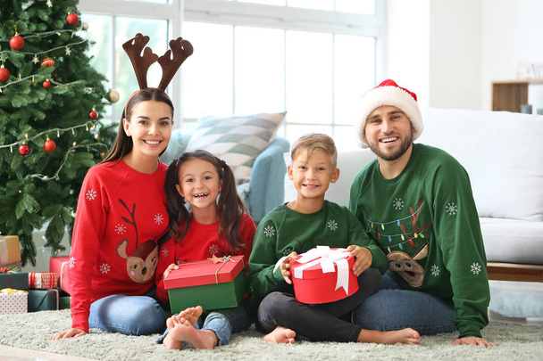 Ευτυχισμένη οικογένεια με δώρα στο σπίτι την παραμονή των Χριστουγέννων - Φωτογραφία, εικόνα