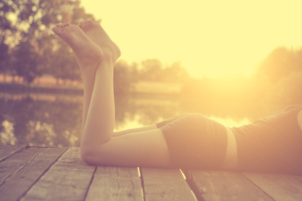 Girl lying on a pier - Foto, immagini