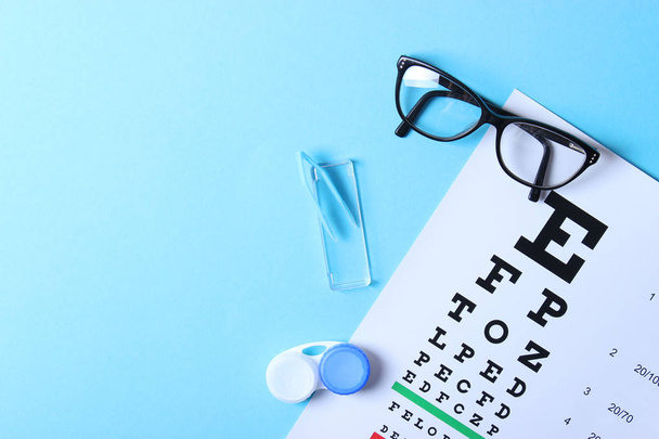 a table for checking vision, glasses and lenses for correcting vision on a colored background, top view. Ophthalmologist Accessories. - Valokuva, kuva