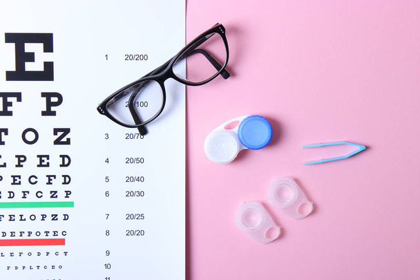 a table for checking vision, glasses and lenses for correcting vision on a colored background, top view. Ophthalmologist Accessories. - Foto, immagini