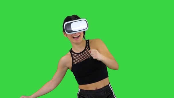 Happy smiling young girl using VR headset glasses playing dancing game First time on a Green Screen, Chroma Key. - Video, Çekim