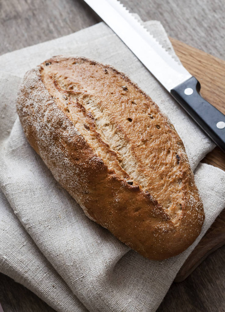 Pane di pane integrale asse di legno sul tavolo della cucina
 - Foto, immagini