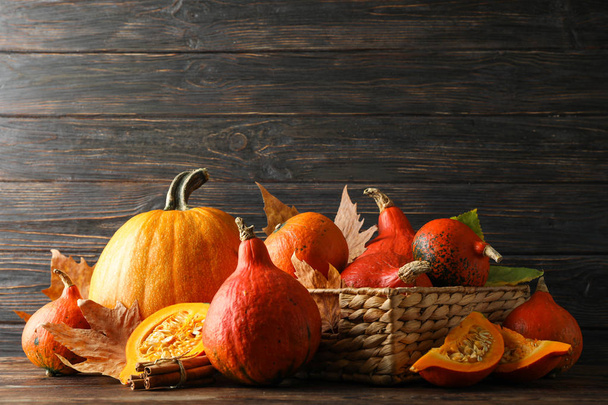 Straw basket, pumpkins, leaves and cinnamon on wooden background, copy space - Fotografie, Obrázek