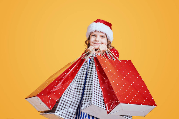 Happy girl in Santa hat with presents - Foto, afbeelding
