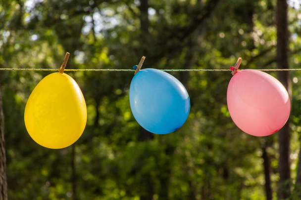 Três balões coloridos soprando no vento ao ar livre na frente
 - Foto, Imagem