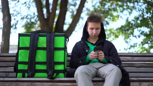 livreur avec sac vert en attente de la commande de livraison - Séquence, vidéo