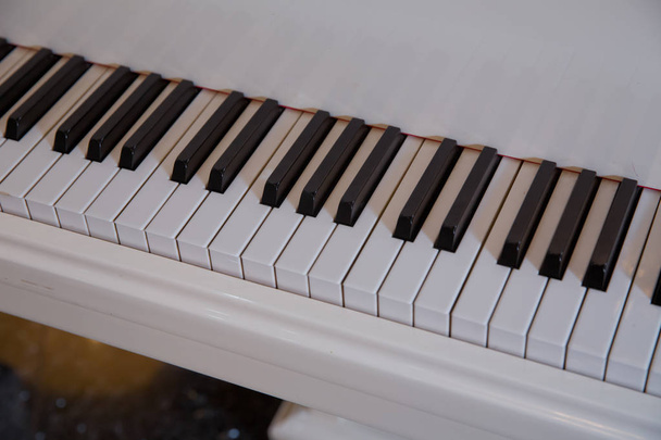 piano näppäimistö kiiltävä musta ja valkoinen avaimet musiikin tausta laaja panoraama banneri muodossa, valittu painopiste, kapea syvyys kentän
 - Valokuva, kuva