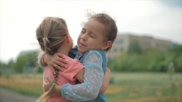 二人の笑顔、カーリー、かわいい姉妹の赤ちゃんの女の子は、お互いにしっかりと抱き合います。幸せな子供時代、肯定的な感情、本当の感情. - 映像、動画