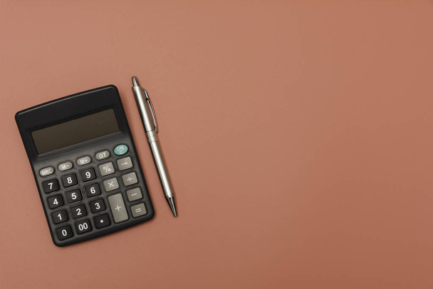 schwarzer Taschenrechner mit Stift und Kopierraum. Technologie und Finanzen - Foto, Bild