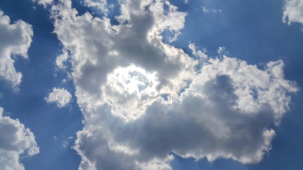 mooie achtergrond van wolken, duidelijk zichtbare lijnen van witte wolken en blauwe hemel, de top is de zonnestraal, wolken als Iron man, het concept van Iron man - Foto, afbeelding