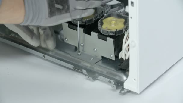 Profesionální opravář uvolňuje přívodní ventil z kovového panelu, který ho drží pohromadě. - Záběry, video