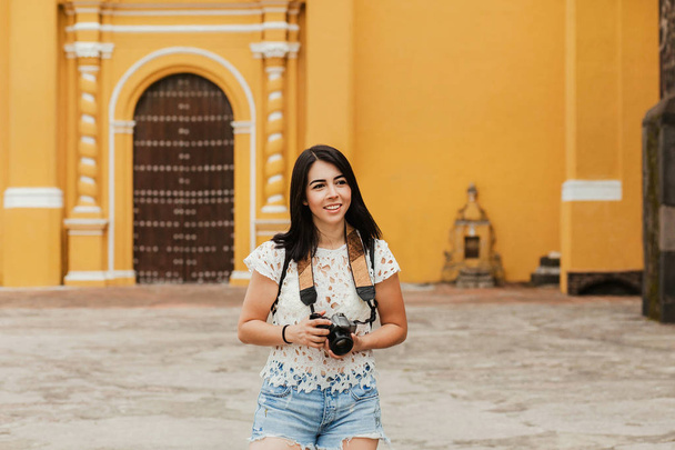 Hispanic girl Making pictures with travel camera in a Mexico trip, summer vacations in latin america - Fotó, kép